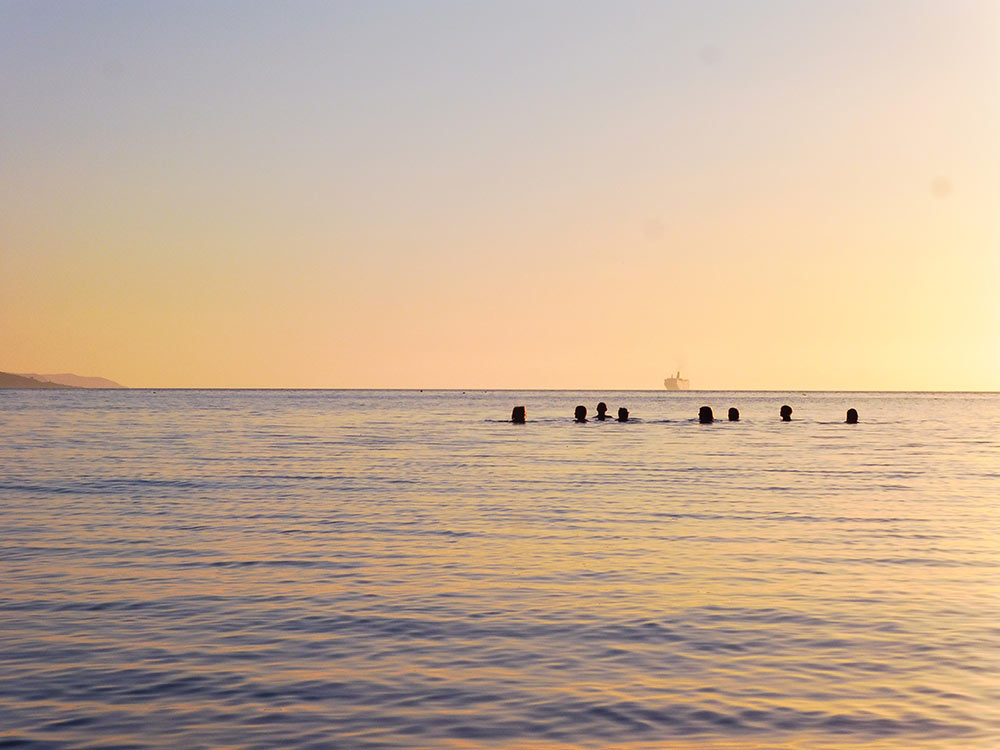 A group of people enjoying a sunset swim